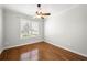 Bright bedroom featuring hardwood floors, a ceiling fan, and a window with plantation shutters at 2997 Mission Lakes Dr, Lakeland, FL 33803