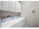 Clean laundry room with white cabinets and modern washer and dryer units at 2997 Mission Lakes Dr, Lakeland, FL 33803
