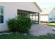 Covered patio has brick pavers and lush landscaping surrounding the exterior of the home at 3817 Osprey Pointe Cir, Winter Haven, FL 33884