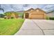Inviting single-story home with a well-manicured lawn, beautiful palm trees, and attached two car garage at 4069 Byrds Crossing Dr, Lakeland, FL 33812