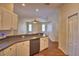 Open concept kitchen features stainless steel dishwasher, white cabinetry, and bar seating overlooking the living area at 4069 Byrds Crossing Dr, Lakeland, FL 33812
