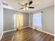 Bedroom features wood-look flooring, natural light from the windows and a ceiling fan at 5458 Quarry Rock Rd, Lakeland, FL 33809