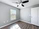 Well-lit bedroom featuring dark wood floors and a window at 5458 Quarry Rock Rd, Lakeland, FL 33809