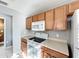 Cozy kitchen featuring wooden cabinets, white appliances, and tile floors at 5458 Quarry Rock Rd, Lakeland, FL 33809