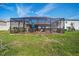 A screened-in patio and green lawn provide an outdoor living space in the backyard at 5543 Arlington River Dr, Lakeland, FL 33811