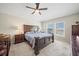 Spacious bedroom with a large bed, neutral carpet, ceiling fan, and bright natural light from several windows at 5543 Arlington River Dr, Lakeland, FL 33811