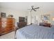 This primary bedroom features a ceiling fan, carpet, large bed, and a view into the en-suite bathroom at 5543 Arlington River Dr, Lakeland, FL 33811