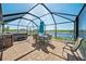 Screened patio with a table, chairs, and hot tub overlooking the lake at 5543 Arlington River Dr, Lakeland, FL 33811