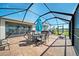 Enclosed patio featuring brick flooring, a dining table, and views of the well-maintained backyard and neighborhood at 5543 Arlington River Dr, Lakeland, FL 33811