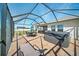 Covered screened patio featuring a hot tub and outdoor dining area with a water view at 5543 Arlington River Dr, Lakeland, FL 33811