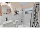 Charming bathroom with round mirror, black hardware, stylish sink, and shower with black and white curtain at 605 Forrest Dr, Bartow, FL 33830