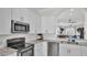 Well-lit kitchen featuring white cabinets, granite countertops, and stainless steel appliances at 6775 Lake Clark Dr, Lakeland, FL 33813