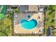 Overhead view of a uniquely shaped pool surrounded by lounge chairs and tables within a fenced in area at 6775 Lake Clark Dr, Lakeland, FL 33813