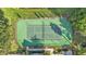 Aerial view of a well-maintained tennis court surrounded by lush greenery and shade trees at 6775 Lake Clark Dr, Lakeland, FL 33813