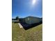 Green backyard with a view of the rear of the house showing a brick patio at 8181 Bristol Bay Ave, Lakeland, FL 33810