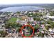 Aerial view of the property featuring mature landscaping, a serene lake, and nearby educational institution at 923 Lexington St, Lakeland, FL 33801