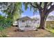 Cozy backyard featuring patio, seating, lush foliage, and a large, shady tree for outdoor enjoyment at 923 Lexington St, Lakeland, FL 33801