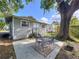 Comfortable outdoor seating area with metal chairs, a large patio, and mature trees in the backyard at 923 Lexington St, Lakeland, FL 33801