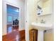 Cozy bathroom showcases a pedestal sink and offers a glimpse into the dining area at 923 Lexington St, Lakeland, FL 33801