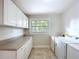 Bright laundry room includes a utility sink, washer, dryer, and ample counter space at 923 Lexington St, Lakeland, FL 33801