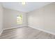 Cozy bedroom featuring light walls, bright window, and new wood-look flooring at 1338 33Rd St Nw, Winter Haven, FL 33881