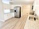 Bright kitchen with stainless steel refrigerator, granite counters, and new wood-look flooring at 1338 33Rd St Nw, Winter Haven, FL 33881