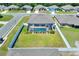 Aerial view of the fenced in backyard, pool, lanai, landscaping and neighborhood at 140 Heritage Park Ln, Mulberry, FL 33860