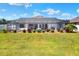 Expansive backyard featuring lush green grass, mature landscaping, and a screened-in lanai with a beautiful pool at 140 Heritage Park Ln, Mulberry, FL 33860