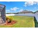 Landscaped backyard featuring lush green grass, mature landscaping and secure fence at 140 Heritage Park Ln, Mulberry, FL 33860