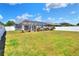 Large backyard featuring lush green grass, mature landscaping, and a screened-in lanai with a beautiful pool at 140 Heritage Park Ln, Mulberry, FL 33860