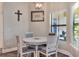 Cozy breakfast nook with white round table, four chairs, and natural light from a window at 140 Heritage Park Ln, Mulberry, FL 33860