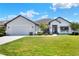 Charming single-story home featuring a manicured lawn and a welcoming front porch at 140 Heritage Park Ln, Mulberry, FL 33860