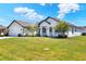 Inviting single-story home with lush landscaping, a well-maintained lawn, and attached two car garage at 140 Heritage Park Ln, Mulberry, FL 33860