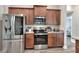 Updated kitchen with stainless steel appliances and brown cabinets at 140 Heritage Park Ln, Mulberry, FL 33860