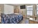Comfortable main bedroom with a blue floral comforter and modern furnishings, including wood-look tile flooring at 140 Heritage Park Ln, Mulberry, FL 33860