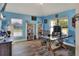 Bright home office with blue walls, wood floors, built-in bookcases, and large windows at 140 Heritage Park Ln, Mulberry, FL 33860
