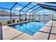 An enclosed pool area under a screened-in enclosure, offering a relaxing space for leisure and recreation at 140 Heritage Park Ln, Mulberry, FL 33860