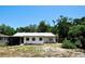 Back exterior view of the home featuring a partially fenced yard with mature trees at 1618 Crystalview Trl, Lakeland, FL 33801