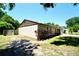 Side view of a well-maintained home with partial fencing and mature trees at 1618 Crystalview Trl, Lakeland, FL 33801