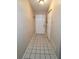 Hallway with tile floors and neutral walls leading to the front door and a closet at 1618 Crystalview Trl, Lakeland, FL 33801