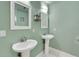 Charming bathroom featuring two pedestal sinks and decorative birdhouse wall art at 202 Saint Lucie Rd, Winter Haven, FL 33884