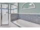 Bright bathroom features a bathtub and walk-in shower with striking blue tile accents at 202 Saint Lucie Rd, Winter Haven, FL 33884