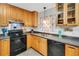 Classic kitchen with wood cabinets, black appliances, and a functional layout for easy cooking at 202 Saint Lucie Rd, Winter Haven, FL 33884