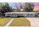 Charming single-story home with a well-manicured lawn, mature trees, and a welcoming walkway at 2410 Nw Avenue B, Winter Haven, FL 33880