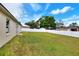 Large backyard with white fence, green grass and blue sky at 7968 Charleston Blvd, Lakeland, FL 33810