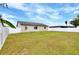 Large backyard space with a white privacy fence, green grass and blue sky at 7968 Charleston Blvd, Lakeland, FL 33810