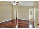 Bedroom with hardwood floors, a ceiling fan, and an ensuite bathroom, creating a comfortable space at 7968 Charleston Blvd, Lakeland, FL 33810