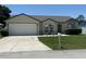 Charming single-story home featuring a two-car garage and well-maintained landscaping at 7968 Charleston Blvd, Lakeland, FL 33810