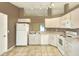 Kitchen featuring white cabinets, white appliances, tile floors, and a pass-through window at 7968 Charleston Blvd, Lakeland, FL 33810