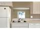 Bright kitchen featuring a stainless steel sink, white appliances, and tile flooring, open concept design at 7968 Charleston Blvd, Lakeland, FL 33810